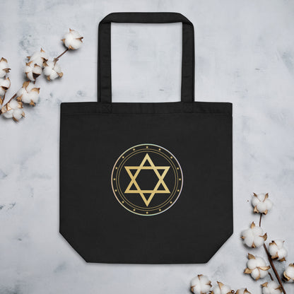 Black tote bag with gold Star of David design on a light gray background with cotton branches.